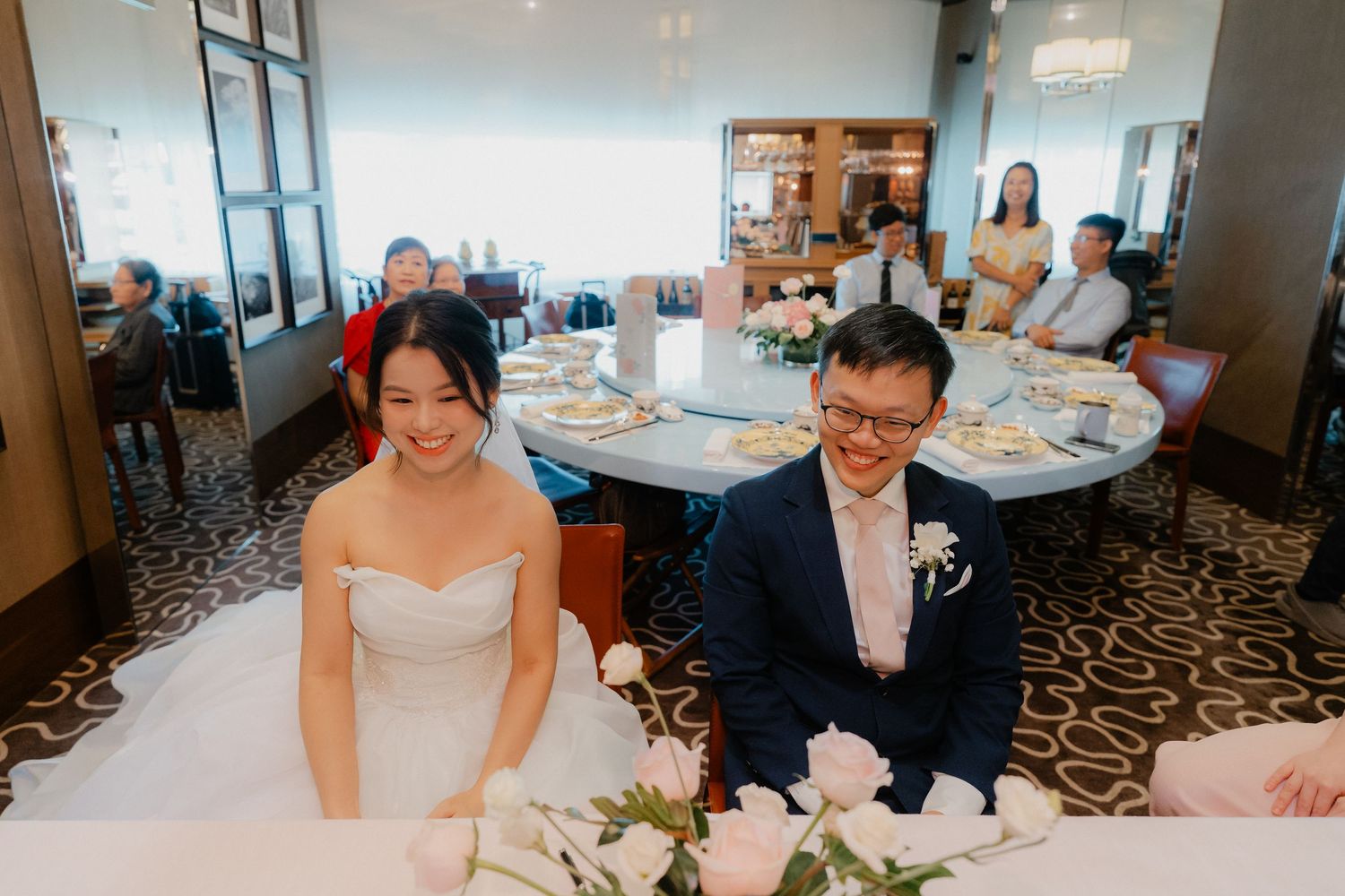 Wedding reception at a modern restaurant with patterned carpeting and table settings.