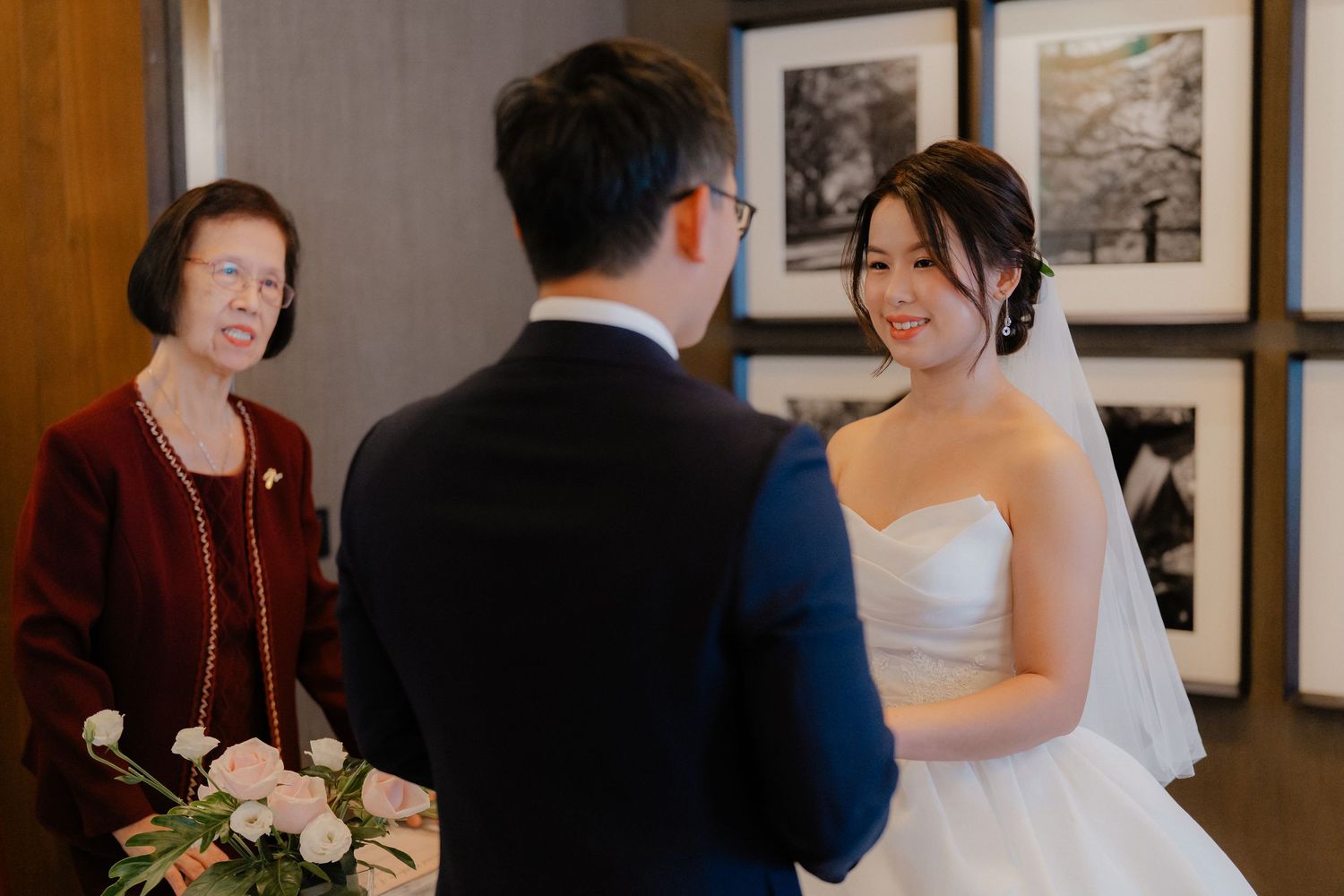 Intimate wedding ceremony moment with burgundy and white floral decor.