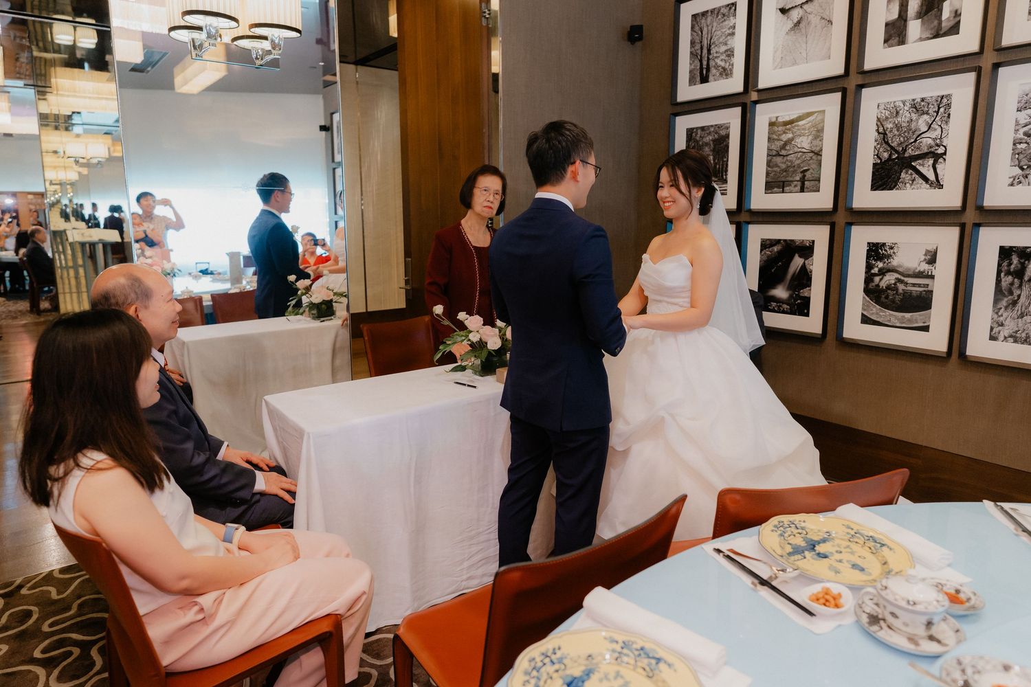 Indoor wedding ceremony with framed photographs decorating the walls.