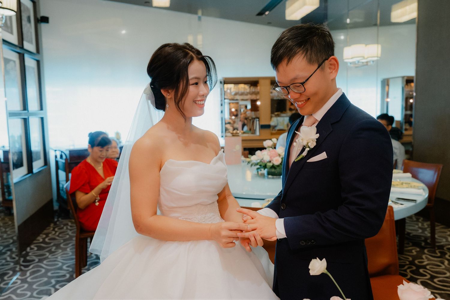A wedding celebration moment in an indoor venue with blue walls and modern decor.