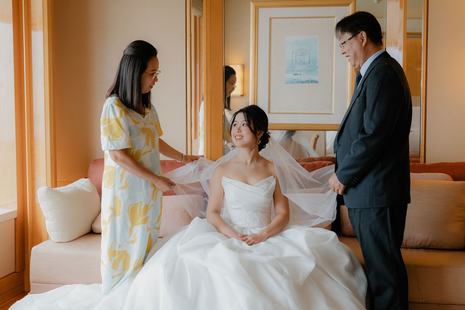 Wedding preparations in a warmly lit hotel room with elegant furniture.