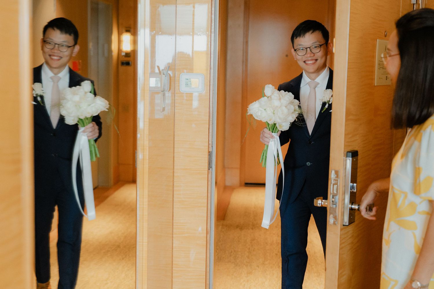 A traditional wedding day arrival moment in a hotel hallway.