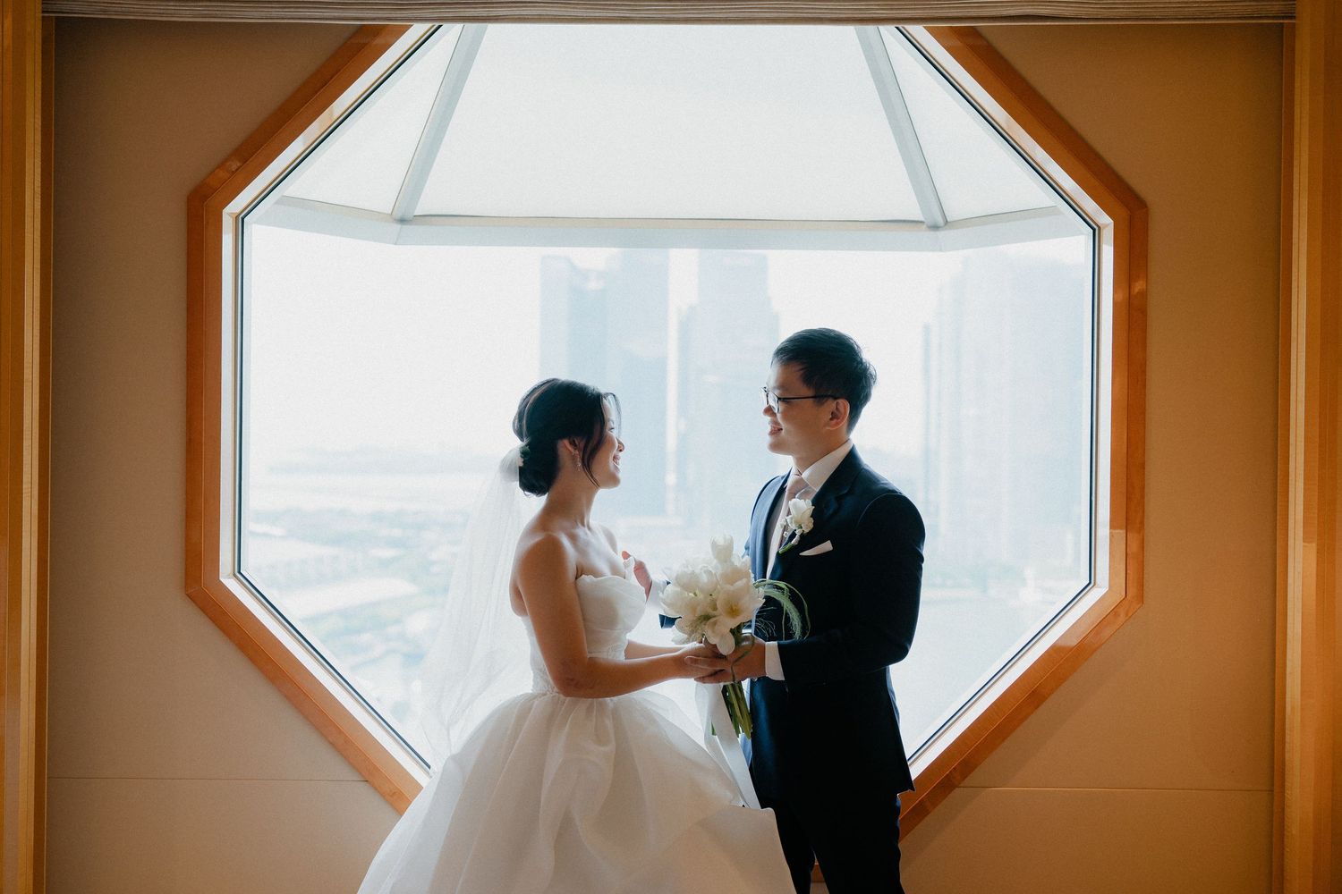 Intimate wedding ceremony captured through three connected octagonal windows with warm lighting and elegant decor.