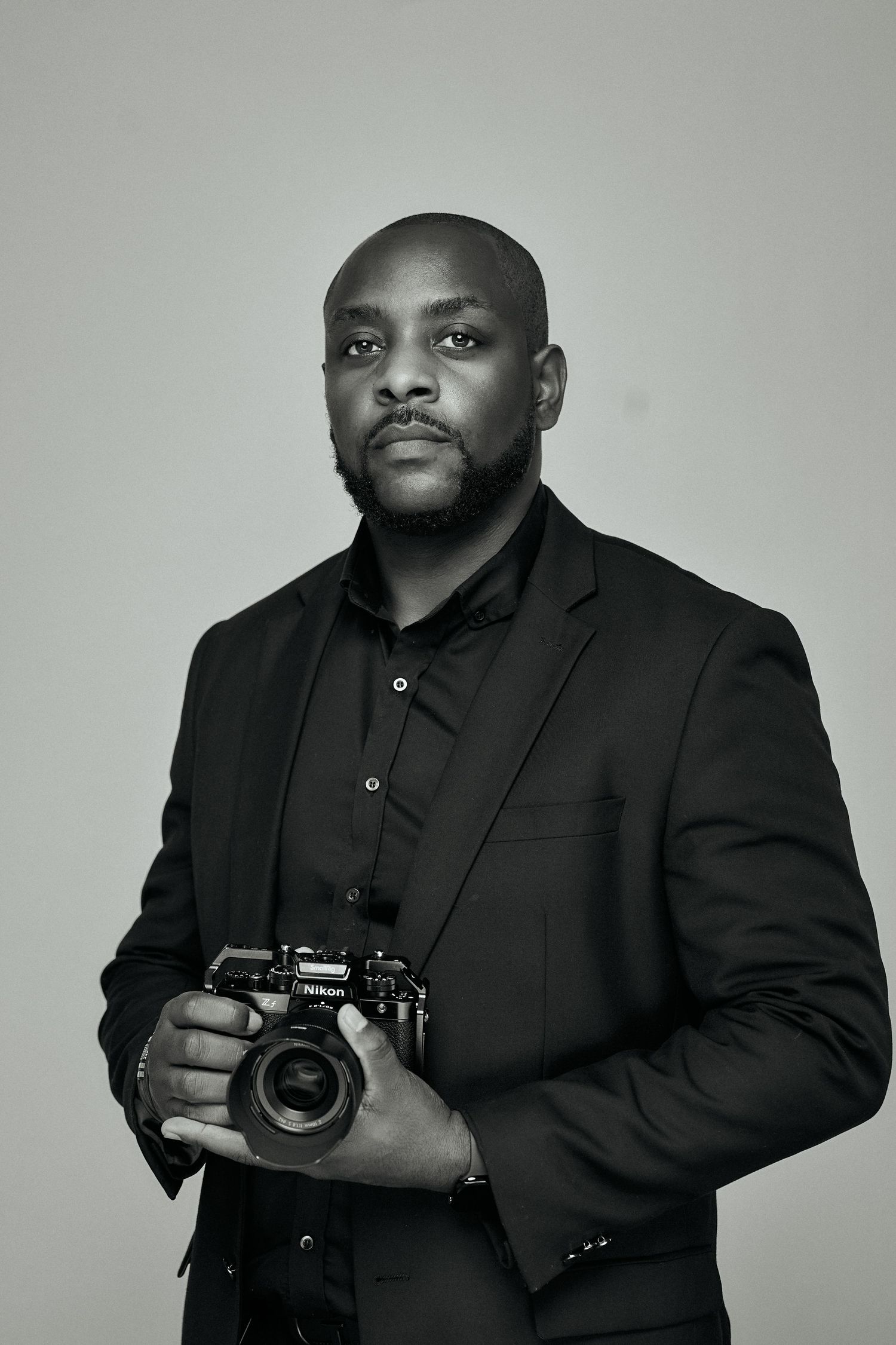 Close up view of a photographer looking through the lens while taking photos wearing a dark sweater.
