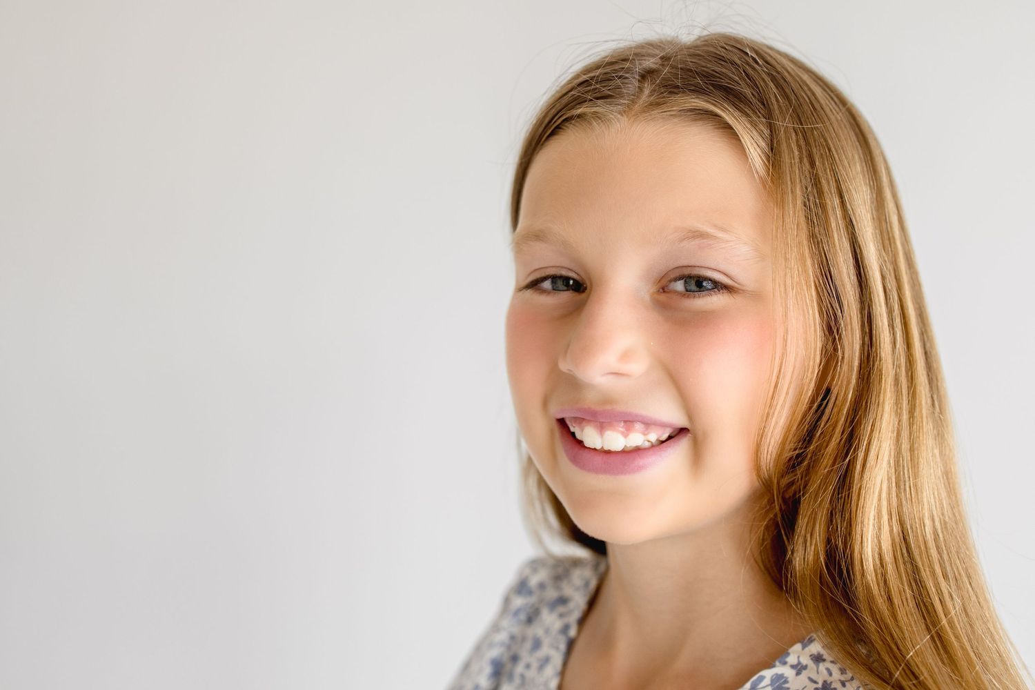 Studio portrait series featuring natural expressions against minimalist white background.