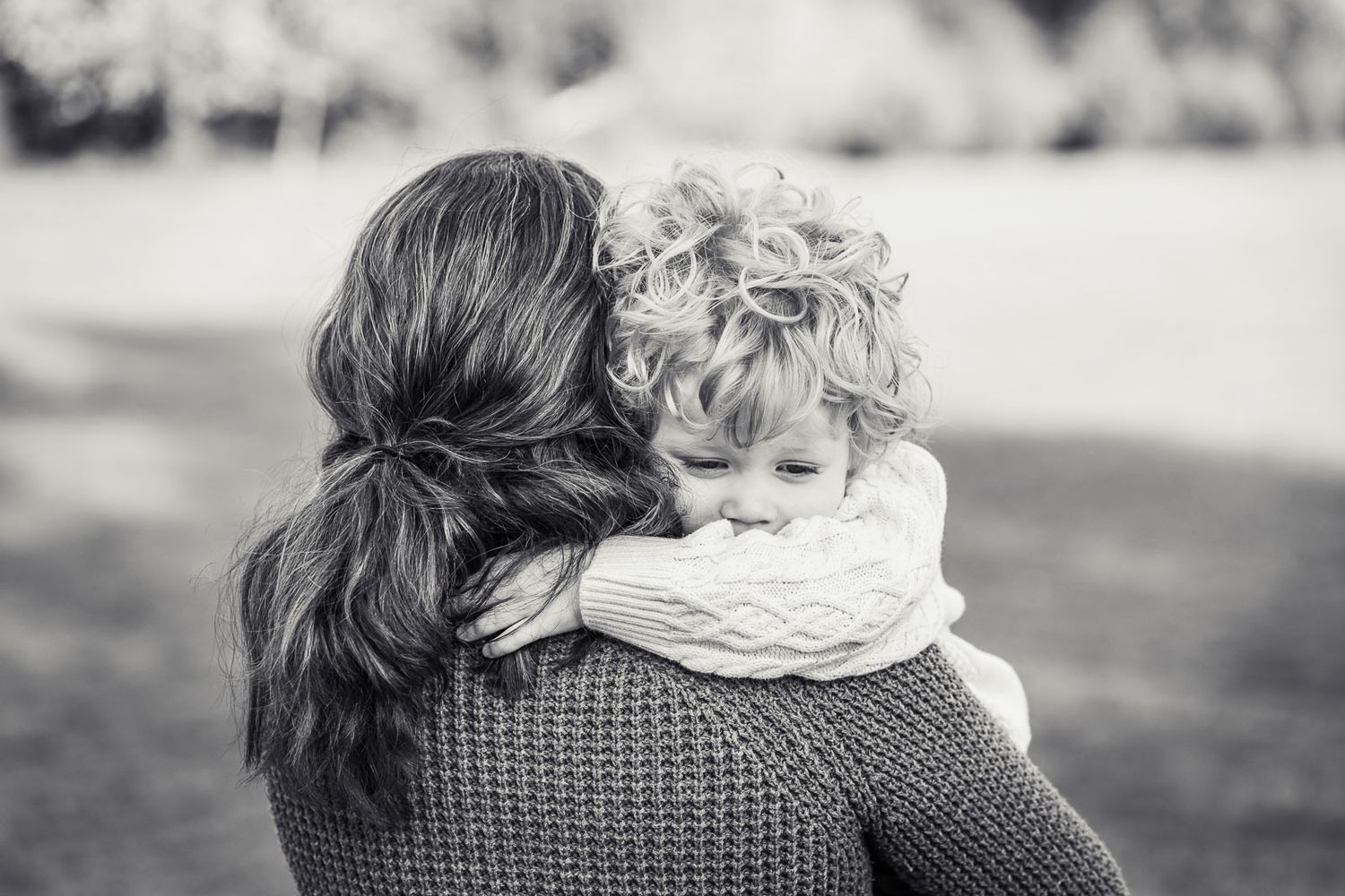 Boy cuddling mom because he's sad.