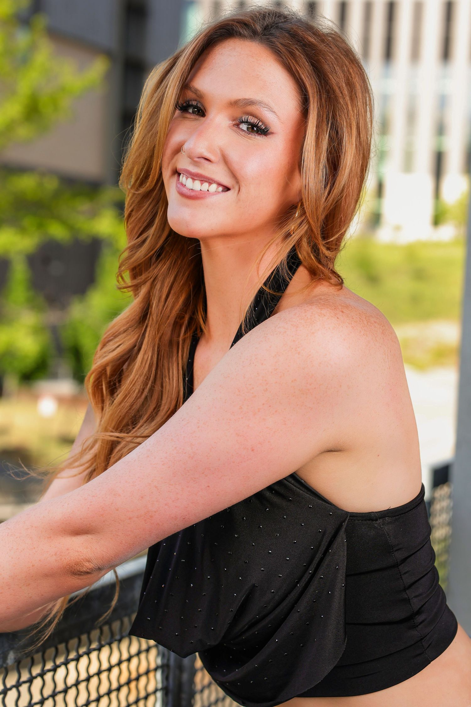 A series of five connected photos shows someone in a black top posing and smiling against an outdoor railing.