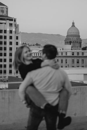 A romantic black and white photo overlooking the state capitol building from a city rooftop at dusk.