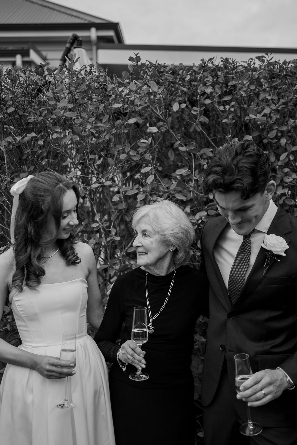Black and white wedding portraits showing tender moments between newlyweds against garden backdrop.