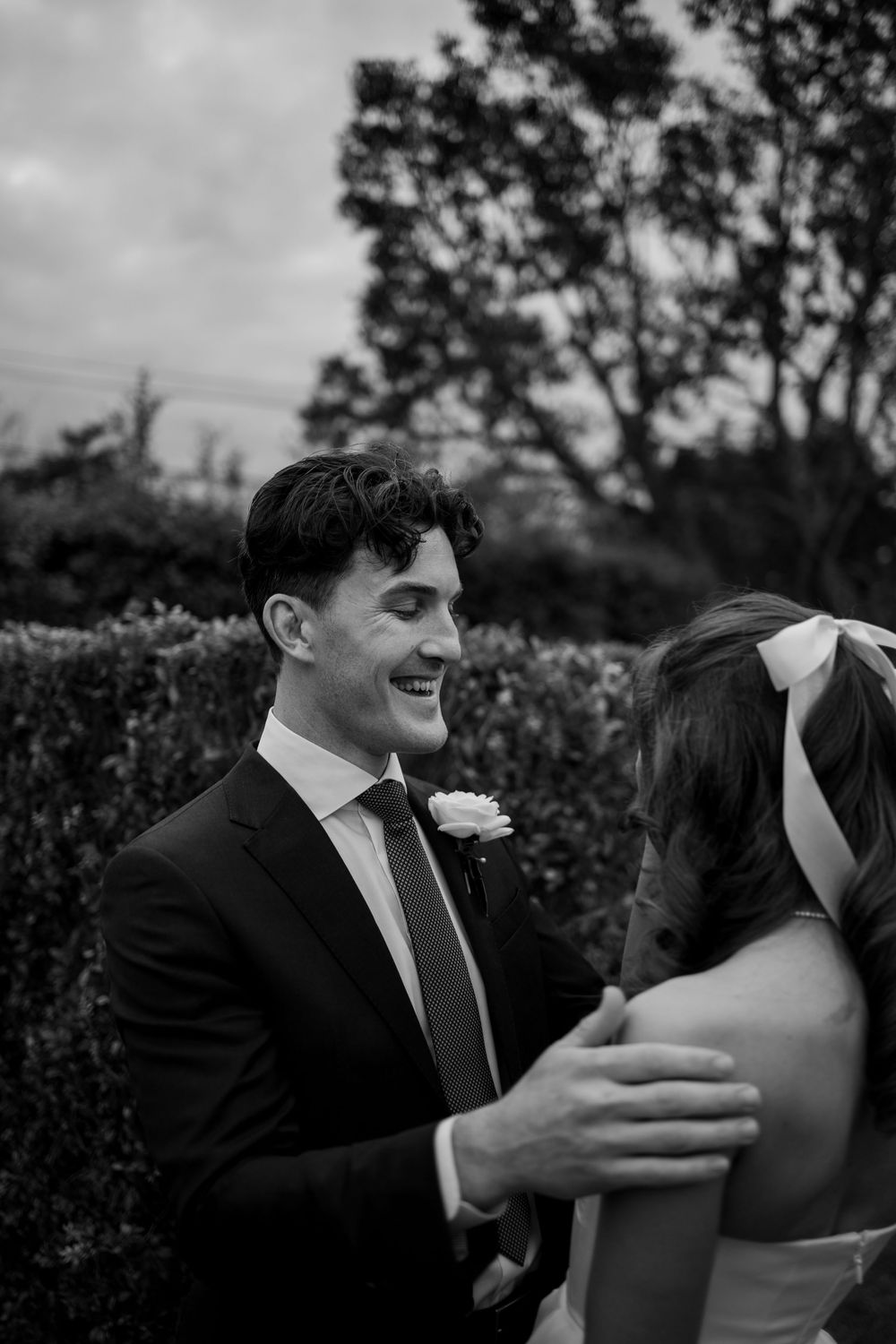 Black and white portraits capture joyful laughter between newlyweds outdoors.