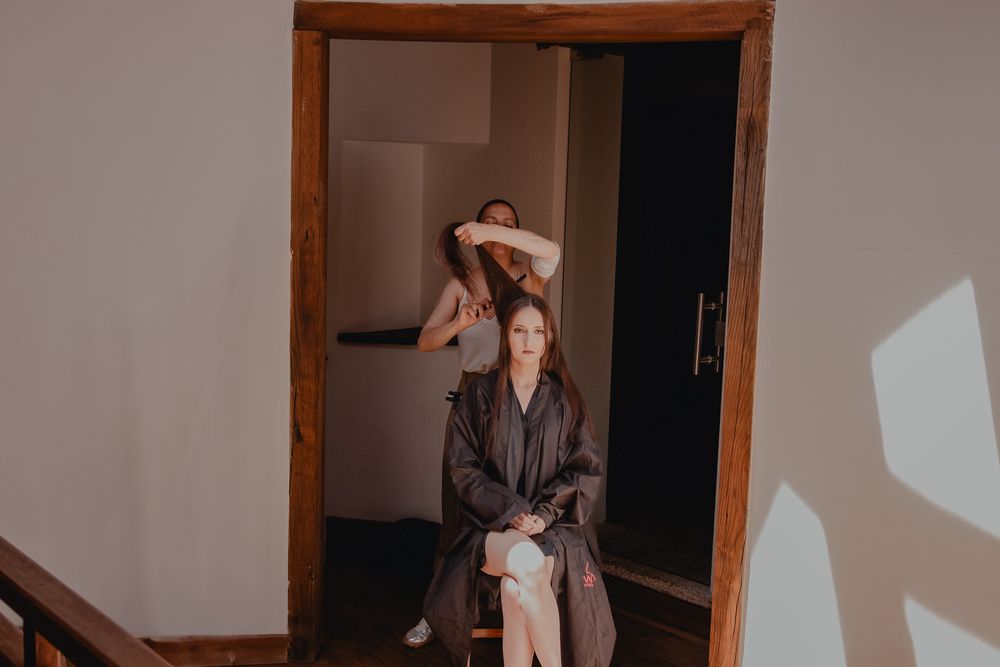 A person sitting in a doorway during what appears to be a photo session.