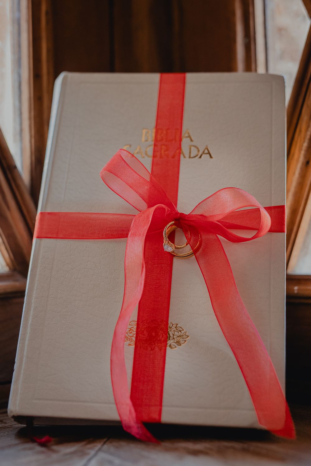 Wedding gift box wrapped in silver paper with a red ribbon bow.