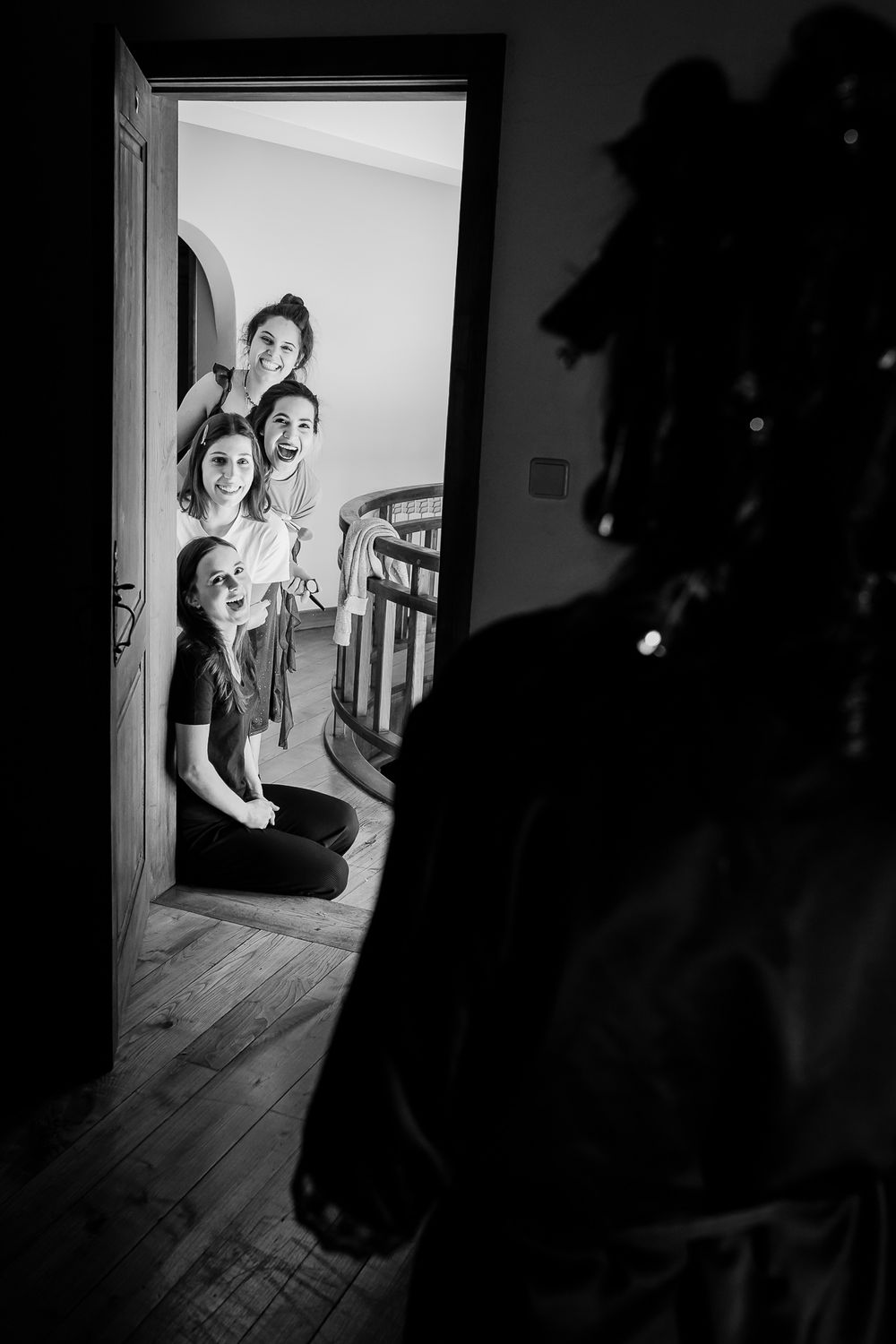 A black and white photo showing people through a doorway with dramatic lighting.
