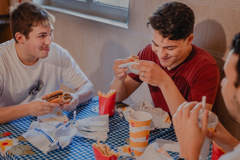People enjoying a casual meal together at a table with a blue checkered tablecloth.