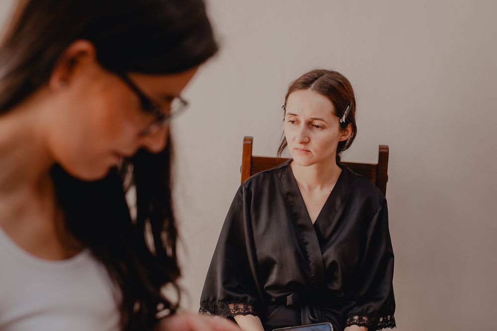 Wedding preparation scene showing makeup application in a cozy indoor setting.