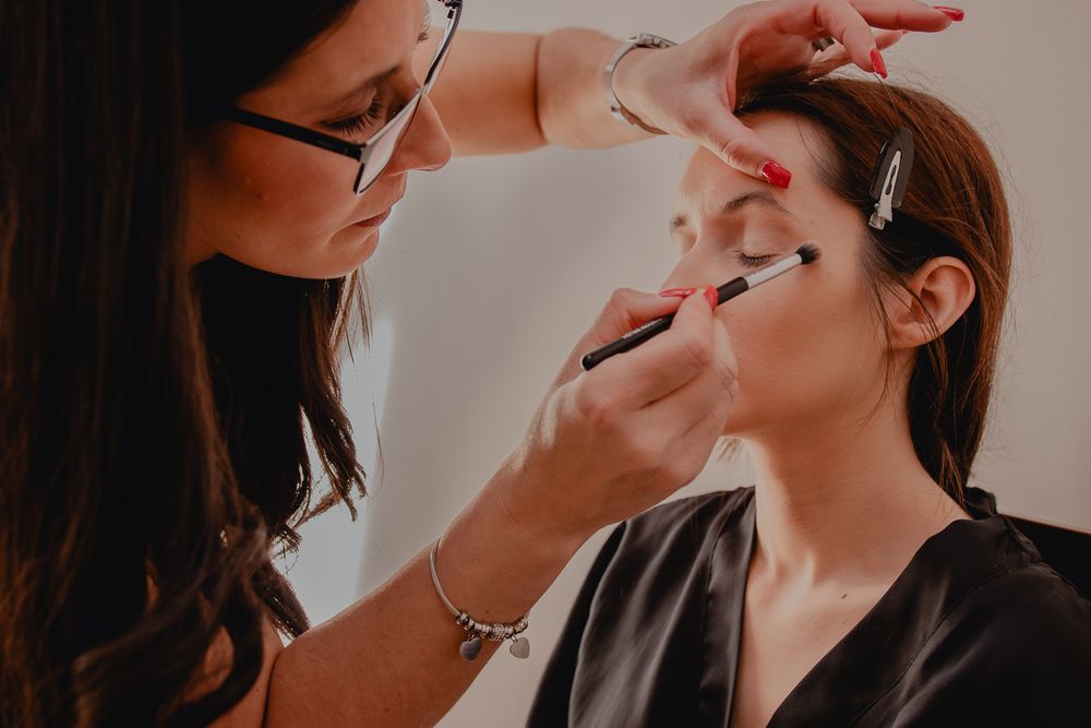 Makeup artist applying eye makeup during bridal preparation.
