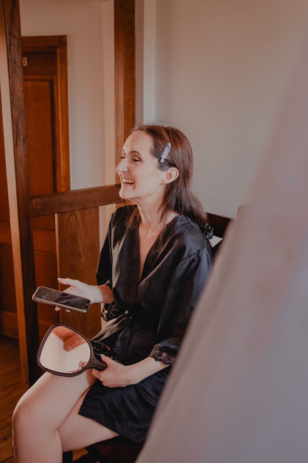 Candid moment during bridal preparations showing joyful laughter.