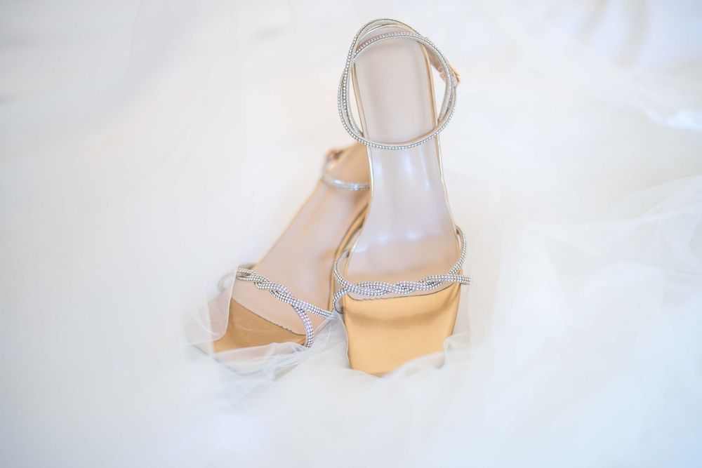 Elegant white bridal sandals displayed against light background.