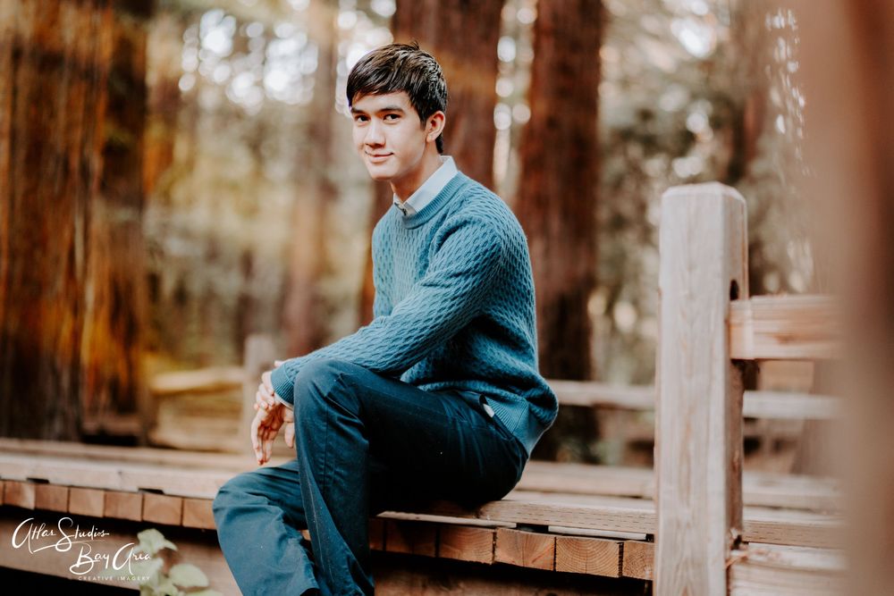 Portrait session among tall trees with rustic wooden elements.