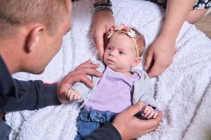 Photo d'un bébé avec ses parents autour