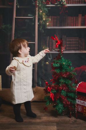 Photo d'un enfant qui décore un sapin de noel