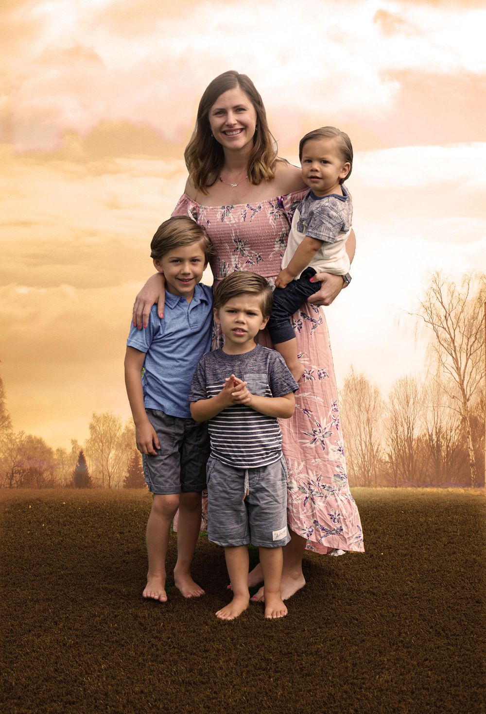 A family poses together in a field at sunset creating a beautiful silhouette against the golden sky.