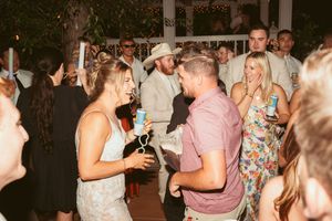 Party atmosphere at outdoor wedding reception with guests socializing and dancing.
