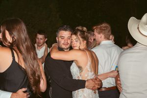 People embracing and dancing together at a wedding reception during an evening celebration.