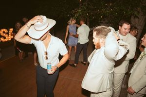 Partygoers in western attire socializing and dancing at an evening celebration.