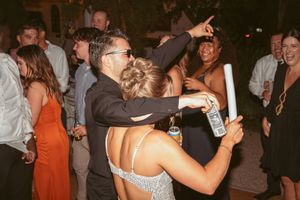 People dancing and socializing at a lively indoor evening celebration.