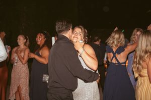 Wedding guests enjoying themselves on a crowded dance floor during reception.