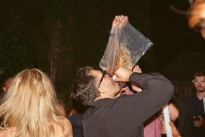 Couples slow dance together at a dimly lit evening party or reception.