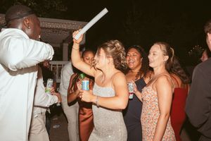 Wedding guests dancing and enjoying themselves on the dance floor at a nighttime reception celebration.