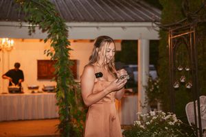 Wedding reception space decorated with hanging greenery and warm ambient lighting.