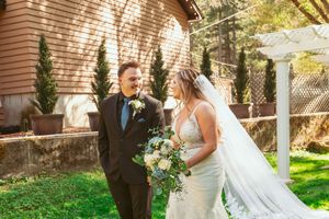 A couple shares a romantic moment beneath a sunny pavilion in the garden during a wedding celebration.