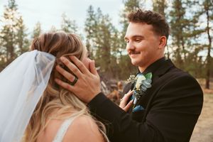 Couple sharing tender moments in forest setting during golden hour with bride wearing white wedding dress.