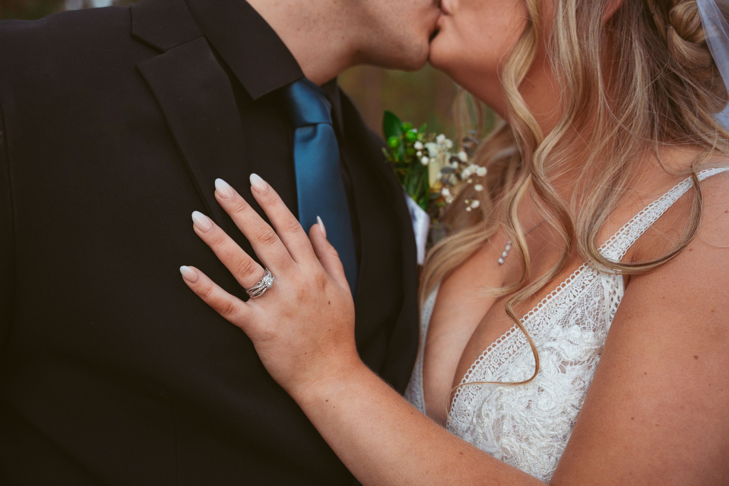 Romantic close-up of wedding couple sharing an intimate moment with sparkling dress detail.