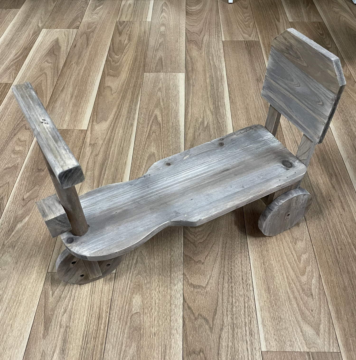 Distressed gray wooden plank on hardwood floor showing weathered texture and rustic finish.