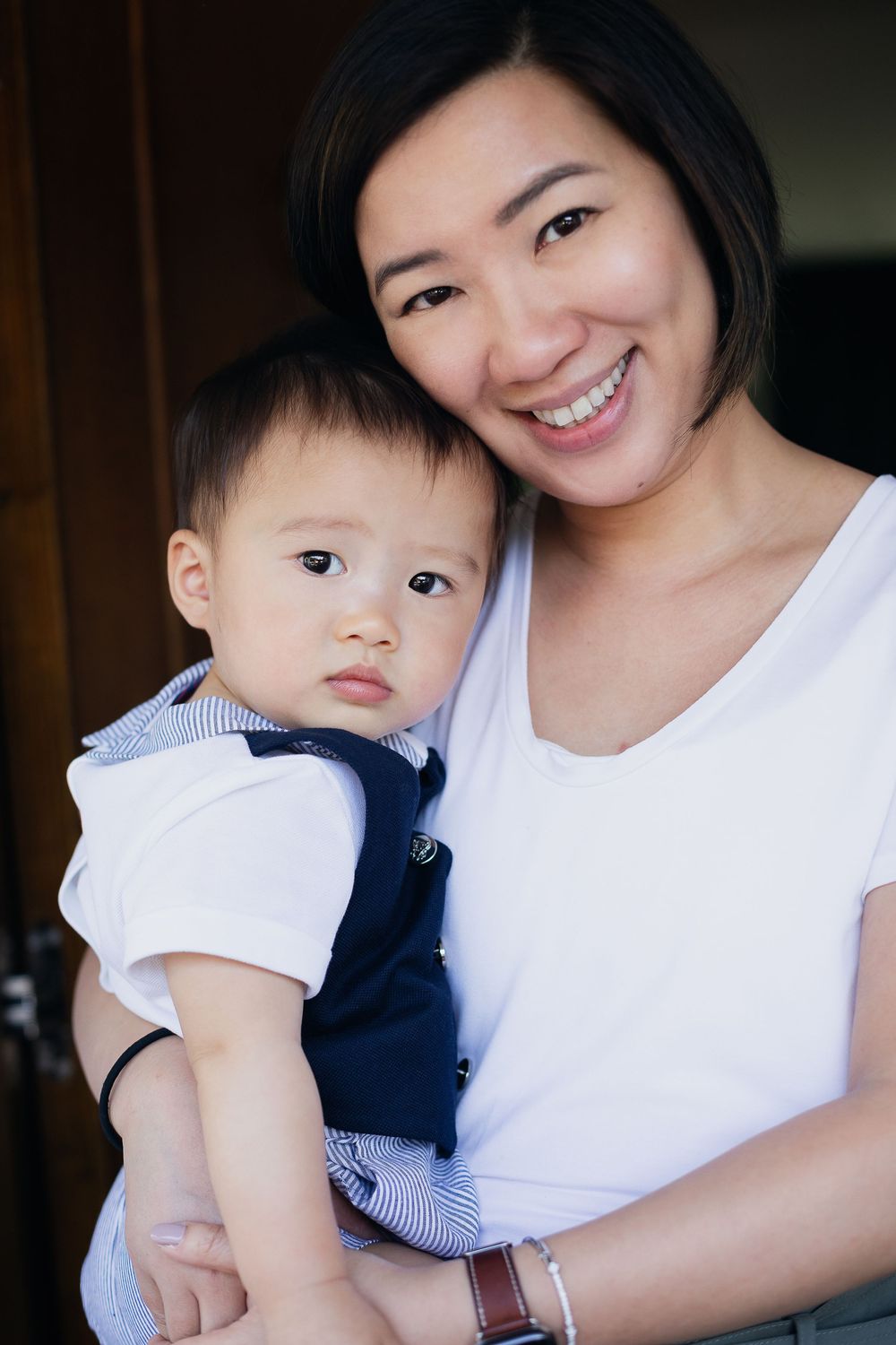 A sweet portrait of affection between parent and baby in matching white tops.