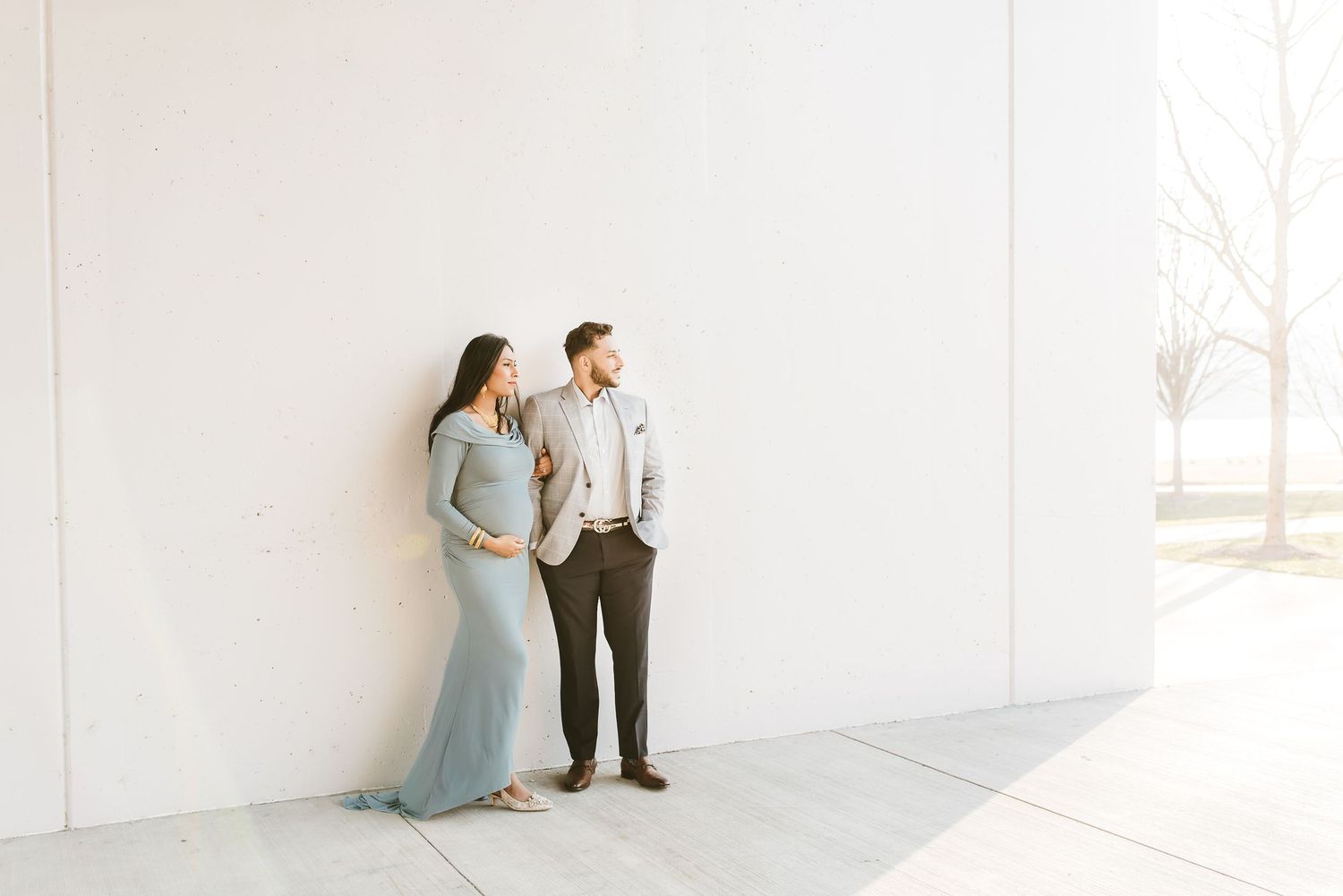 Pregnant woman and partner walking through downtown Cincinnati during a cozy winter maternity photo session