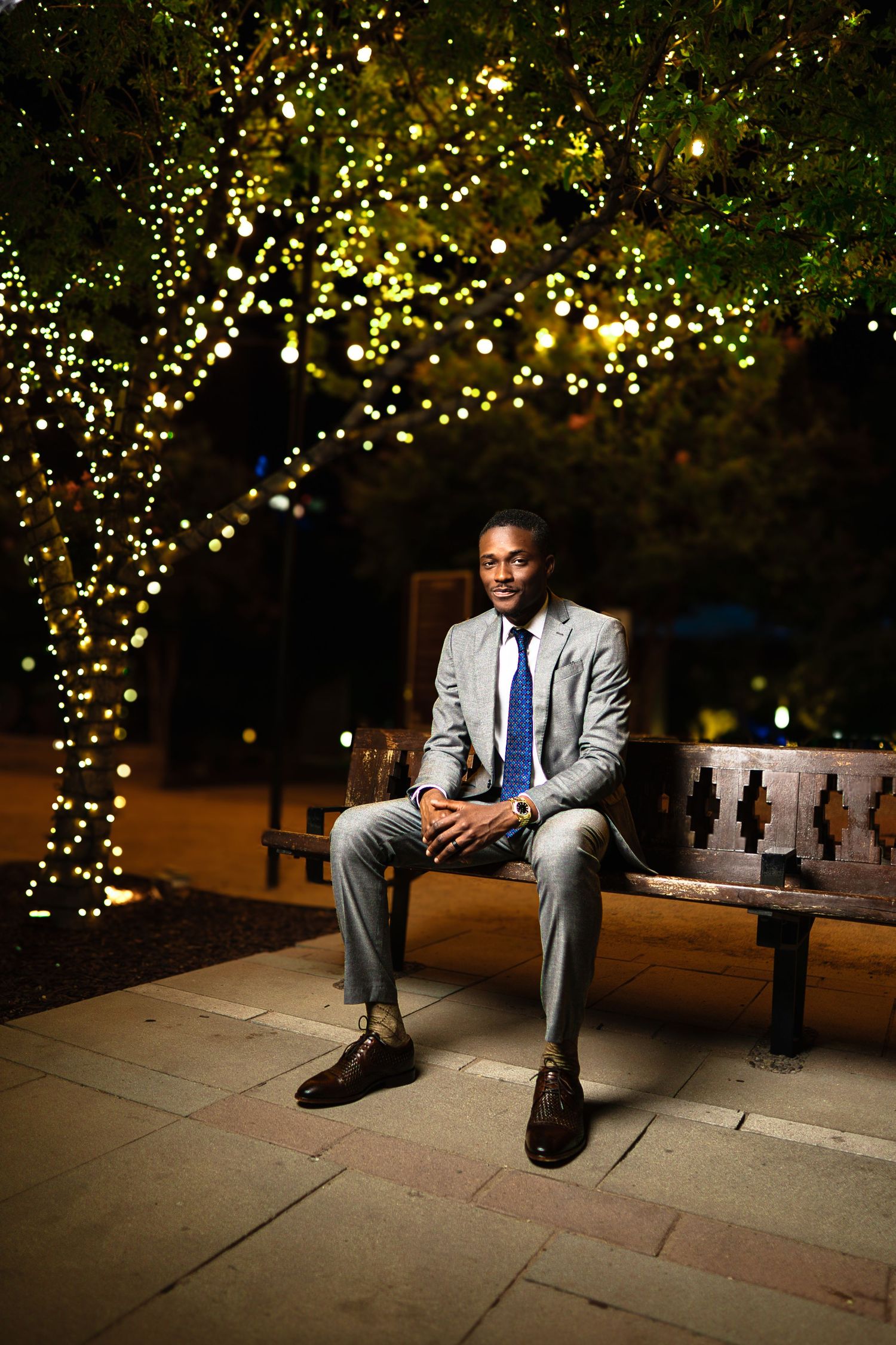 Professional portrait session at night with twinkle lights creating a magical outdoor ambiance.