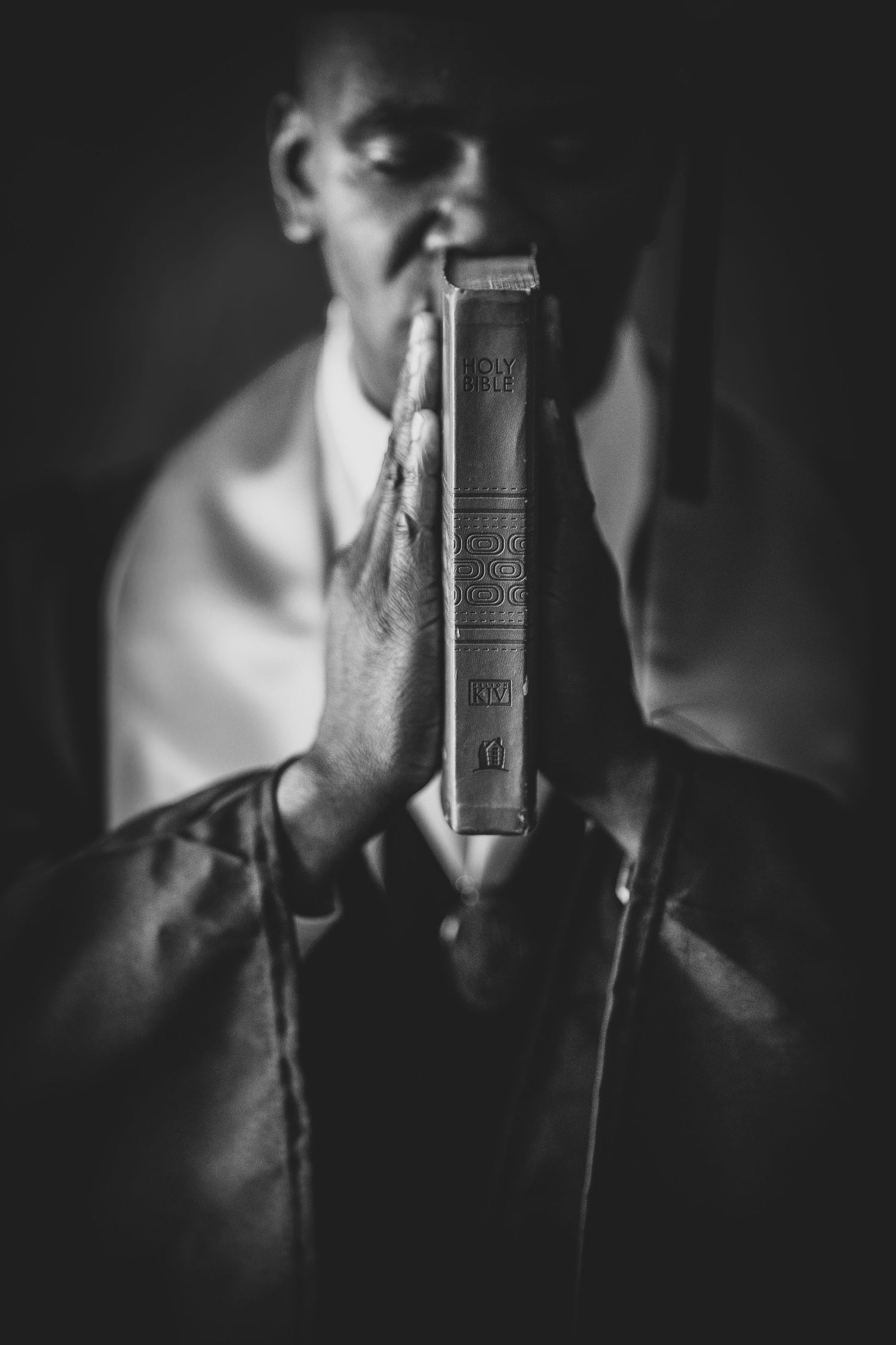 A black and white artistic photo series showing a person holding a vintage book in dramatic lighting.