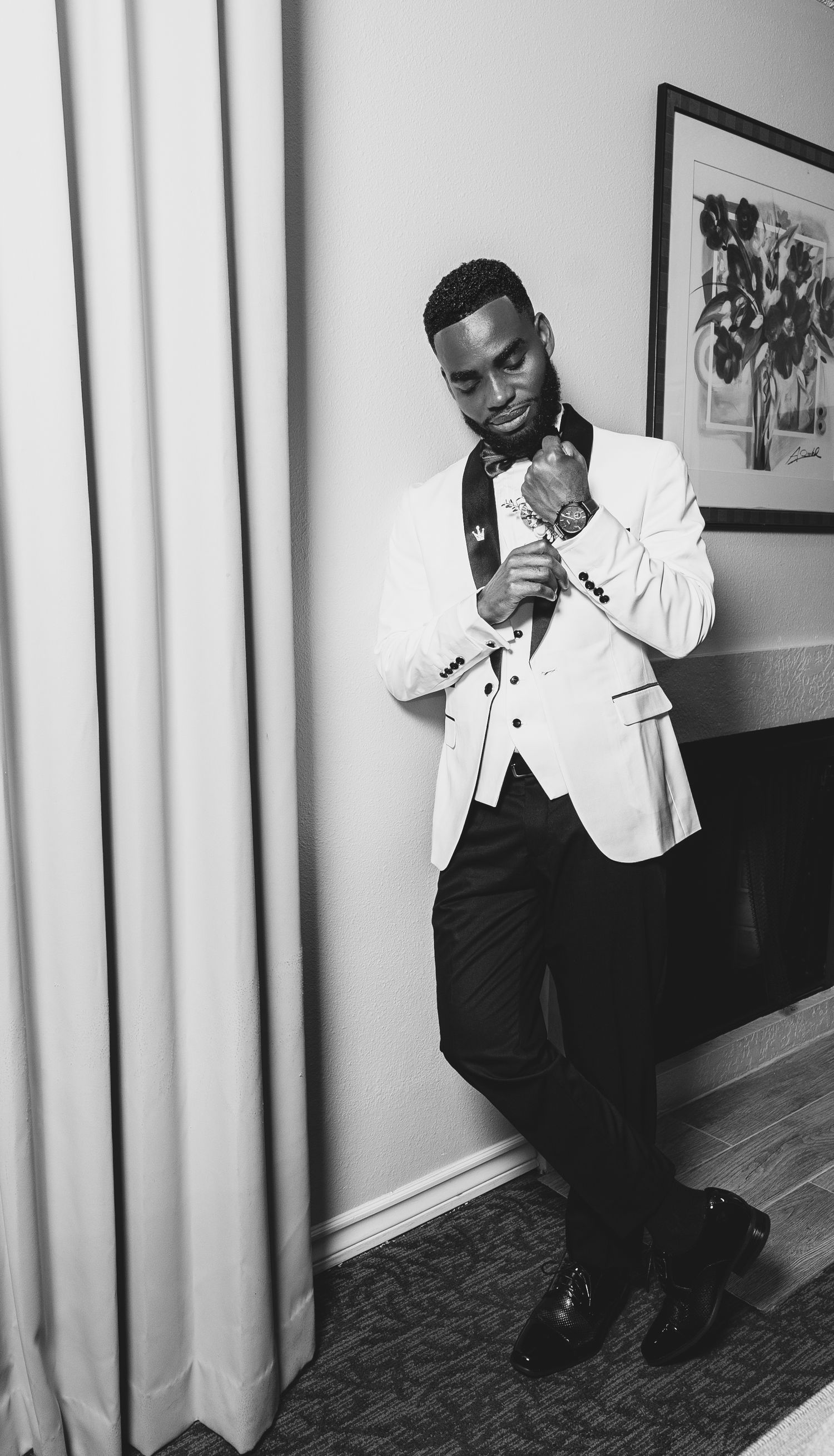 A person in a black and white outfit poses expressively in three similar shots against a light-colored wall.