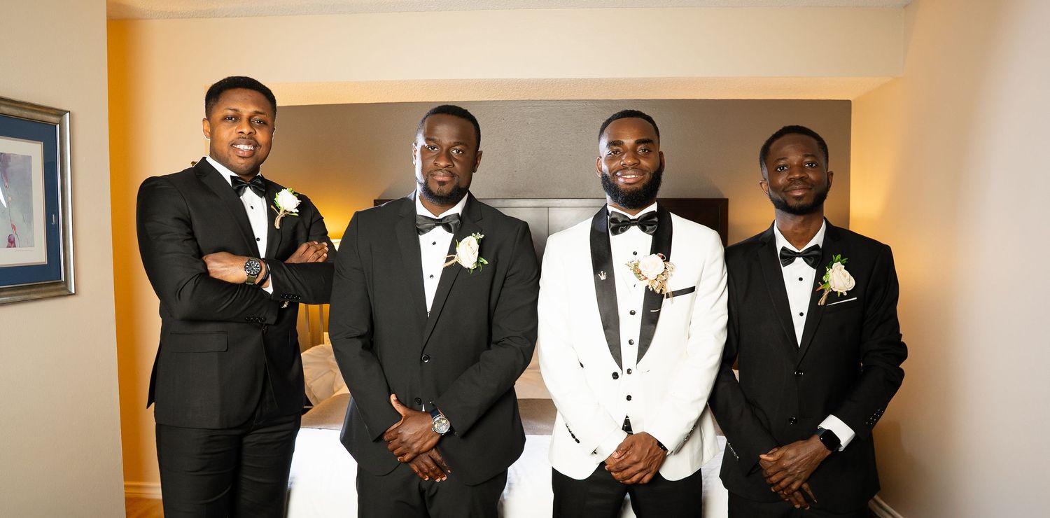 A group in formal black and white attire poses together at an elegant event.