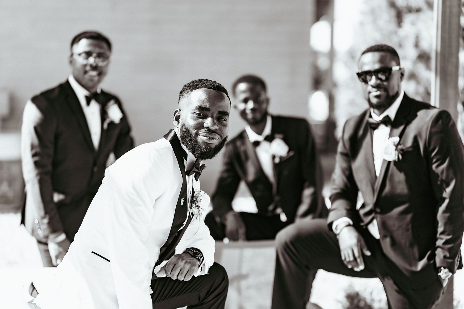 A black and white photograph showing a group of formally dressed people in conversation at an event.