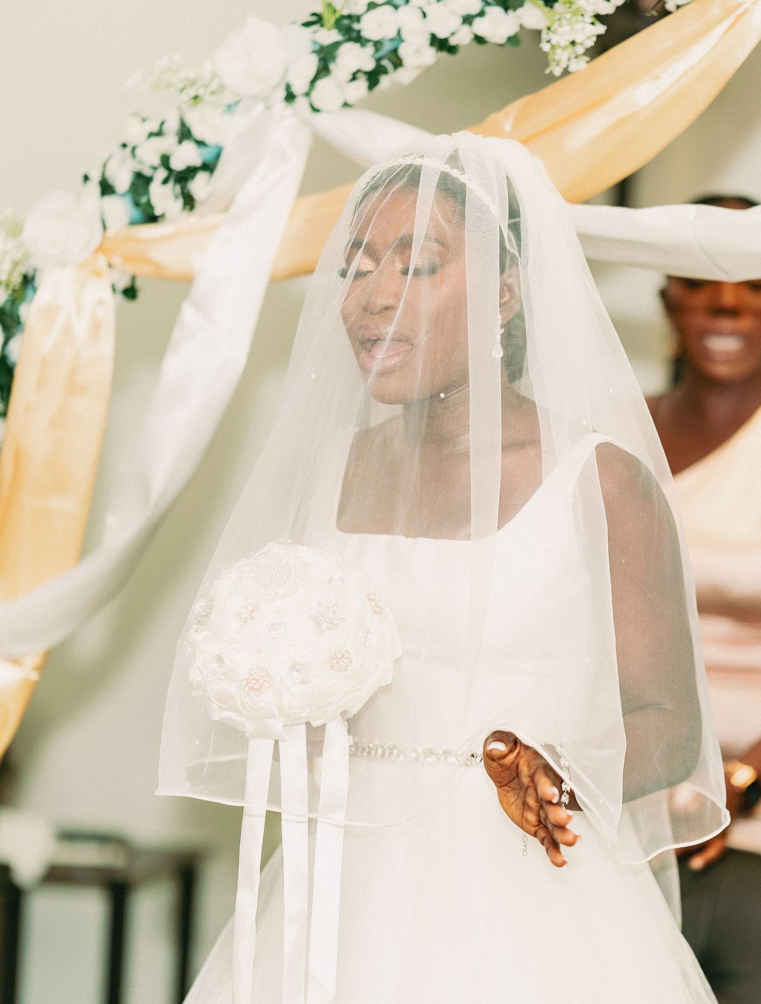 Delicate white bridal veil with lace details flows in a gentle breeze.