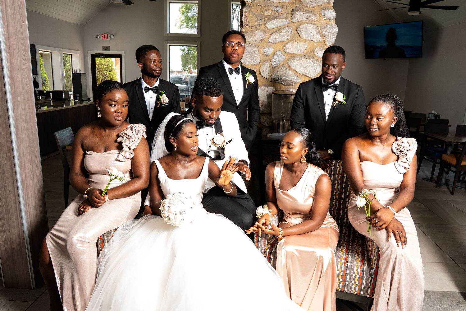 Wedding party members dance and celebrate together in formal attire at an elegant venue.
