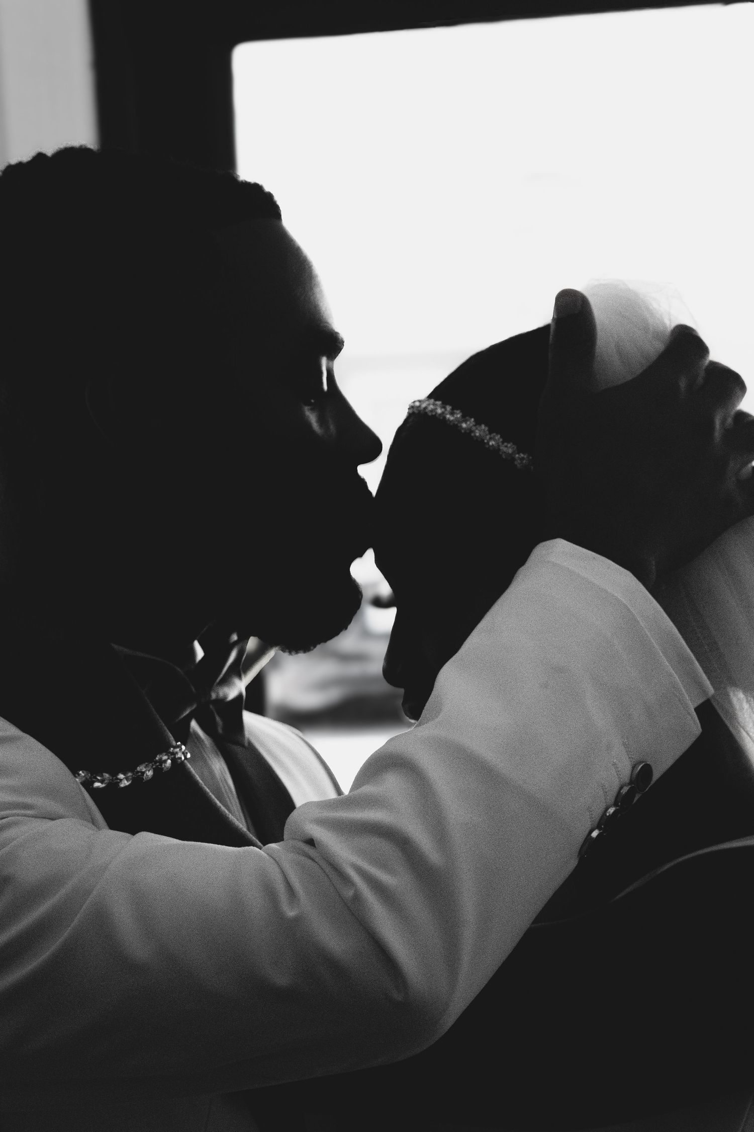 Artistic black and white silhouette profile shot of wedding moments.