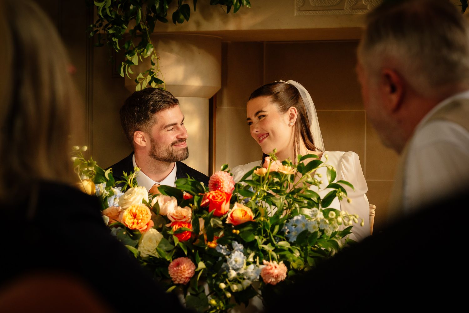 Intimate wedding reception scene with warm lighting and floral arrangements. Ellingham Hall