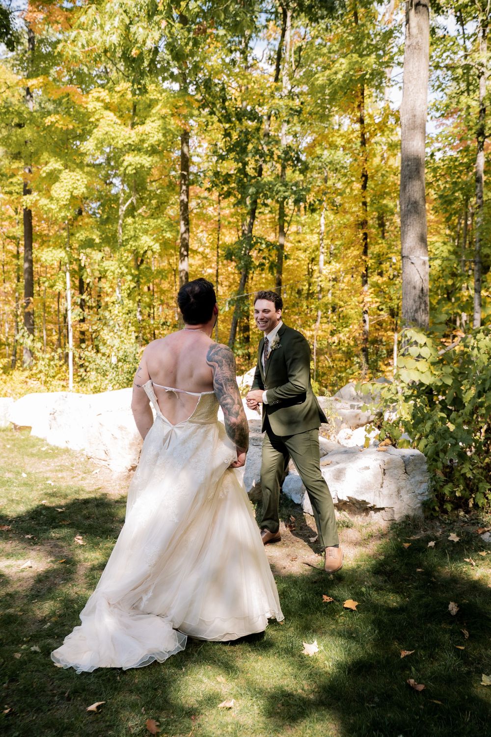 A couple dances together in a sunlit autumn forest setting with golden foliage in the background.